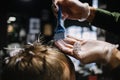 Hairdresser with a brush to apply hair dye. Coloring in the barber shop