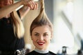 Hairdresser hands cut off blonde tail closeup Royalty Free Stock Photo