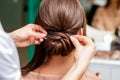 Hairdresser hands making hairdo.