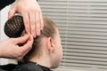 Hairdresser inserts a hairpin under the hairnet