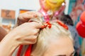 Hairdresser makes braids with red kanekalon