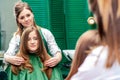 Hairdresser makes hairstyle for woman