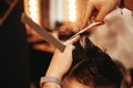 Hairdresser makes Hipster trendy haircut in Barber shop