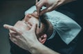 A hairdresser makes a man a haircut of his beard