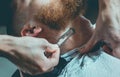 A hairdresser makes a man a haircut of his beard, and a mustache