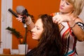 Hairdresser making hair of beautiful happy girl