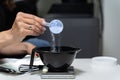 Hairdresser pours dry hair clarifier into mixing bowl