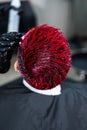 The hairdresser removes excess dye from the skin of a female with a cotton pad.Asian woman with a short haircut in a Royalty Free Stock Photo