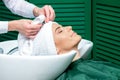 Hairdresser is wrapping woman`s hair in towel Royalty Free Stock Photo