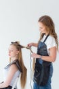 Hairdresser smooths the hair of a client with a curling iron Royalty Free Stock Photo