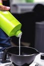 Hairdresser squeezing out hair dye in bowl with paint