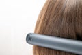 Hairdresser straightening long dark hair with hair irons Royalty Free Stock Photo