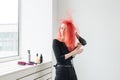 Hairdresser, style, people concept - woman is blowing dry her colored hair Royalty Free Stock Photo