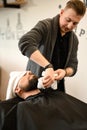 Hairdresser stylist wipes the remains of shaving gel with towel after shaving the beard