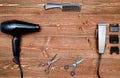 Hairdresser tools on wooden background. Top view on wooden table with scissors, comb, hairclipper and hairdryer, free space.