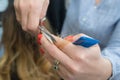 Hairdresser trimming ombre hair with scissors