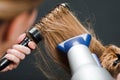 Hairdresser using hairbrush and hair-dryer Royalty Free Stock Photo