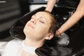 Hairdresser washes head of young woman in beauty salon closeup Royalty Free Stock Photo