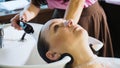 Hairdresser washes woman`s hair in the beauty studio. Royalty Free Stock Photo