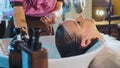 Hairdresser washes woman`s hair in the beauty studio. Royalty Free Stock Photo