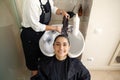 Hairdresser washes woman`s hair, side view Royalty Free Stock Photo