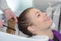 Hairdresser washing and combing customer`s hair Royalty Free Stock Photo