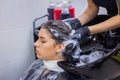 Hairdresser washing hair of woman client