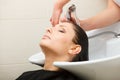 Hairdresser washing her woman customer hair Royalty Free Stock Photo