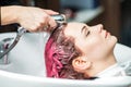 Hairdresser washing pink dyed hair Royalty Free Stock Photo