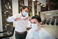 Coronavirus outbreak lifestyle: A hairdresser, wearing a protective face mask,