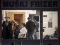 Hairdresser, a woman, cutting the hair of a male client in a hairdressing salon wearing facemask protective equipment during Covid Royalty Free Stock Photo