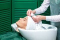 Hairdresser wrapping woman's hair in towel