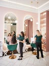 Hairdressers styling women hair in beauty salon. Royalty Free Stock Photo
