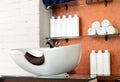 Hairdressing bowl in Beauty Salon Interior. Wash sink for washing hair, hair care spa procedures in Barber shop, shampoos, towels Royalty Free Stock Photo