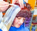 Hairdressing client makes highlights with silver paper sheets Royalty Free Stock Photo
