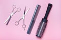 Hairdressing scissors, comb and brushing on pink background, a view from above Royalty Free Stock Photo