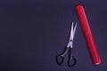 Hairdressing scissors with a red comb on a black background with copy space. Hairdresser tools. Haircut in a beauty salon