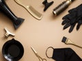 Hairdressing tools on a beige background. Frame of objects hair salon , scissors, gloves, mask, scissors, combs, hair