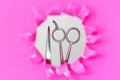 Hairdressing tools comb and scissors on torn pink paper background Royalty Free Stock Photo