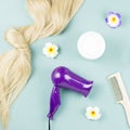 Hairdressing tools, nourishing mask and hair extensions on blue wooden background. Hair care concept flat lay Royalty Free Stock Photo