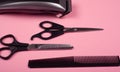 Hairdressing tools on a pink background, clipper, comb and scissors Royalty Free Stock Photo