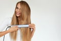 Hairdressing. Woman With Beautiful Long Hair Using Straightener Royalty Free Stock Photo