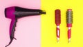 Hairdryer and two hairbrushes appear on pink yellow theme. Stop motion