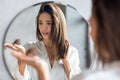 Hairloss Concept. Worried Young Woman Holding Bunch Of Fallen Hair In Hand