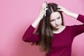 Hairloss And Disorder. Young Caucasian Female Having Hair Problems as Checking Hair in Hairbrush and Posing in Red Dress Against