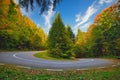 A hairpin in a mountain road in autumn colored forest at sunrise Royalty Free Stock Photo