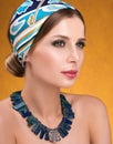 Hairstyle with headscarf. Closeup portrait of young woman with necklace Royalty Free Stock Photo