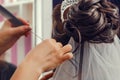 Hairstyling process. Beautiful wedding hairstyle. Hairdresser master making curls. Rear view of stylish close-up hairdress of the Royalty Free Stock Photo