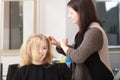 Hairstylist combing client in hairdressing salon