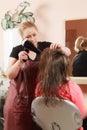 Hairstylist drying teenager hairs